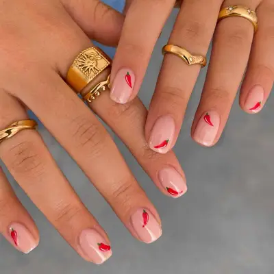 Neutral manicure with small chili pepper emoji nail designs