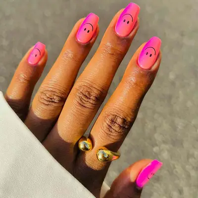 Pink to orange ombre manicure with smiley face emoji nail designs