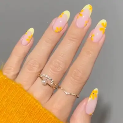 French manicure with yellow tips and darker yellow flowers.