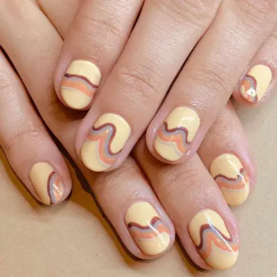 Butter yellow nails with swirly lines in dusty shades of maroon, blue, orange, and cream.