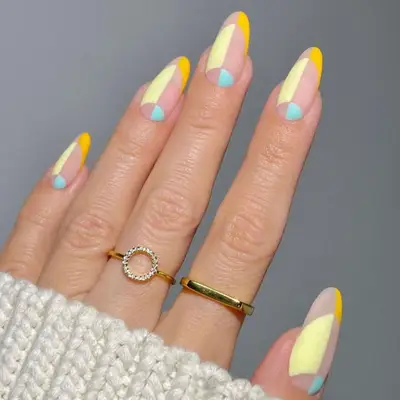 Matte geometric nail art design in nude, deep yellow, butter yellow, and baby blue.