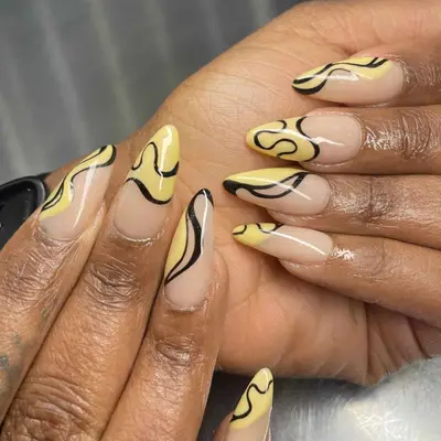 Black and yellow swirls on a nude manicure base.