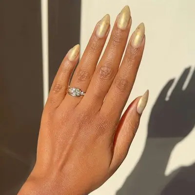 Manicure with gold shimmery cracked polish and almond shape