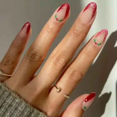A red v-tip French manicure with boughs of holly at the bases