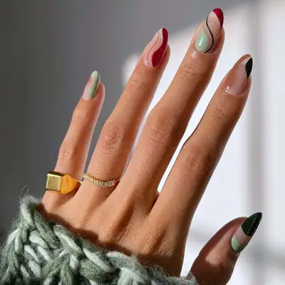 Swirly manicure with red, green, and brown accents