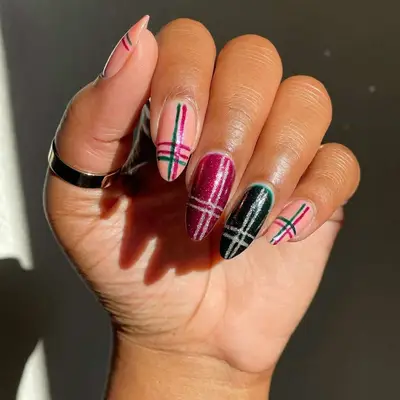 A dark red and green tartan manicure