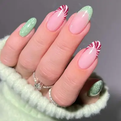 A French manicure with alternating green and peppermint tips