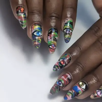 nails with rhinestone eyes and colorful swirls 