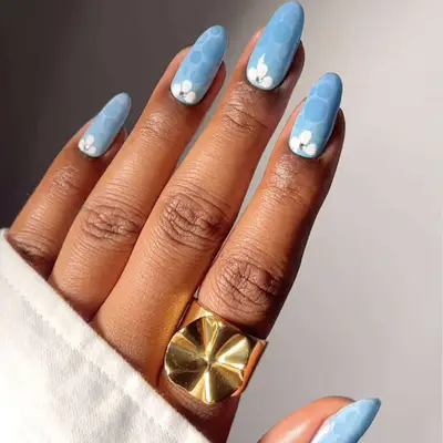 A blue manicure with subtle floral details