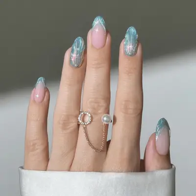 Light blue nails with a pool surface effect and white floral details at the cuticle.