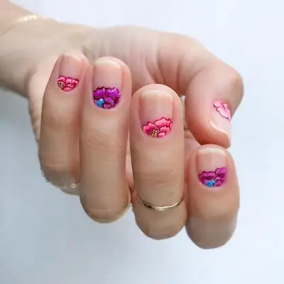 Short nude nails with pink and purple half moon floral design