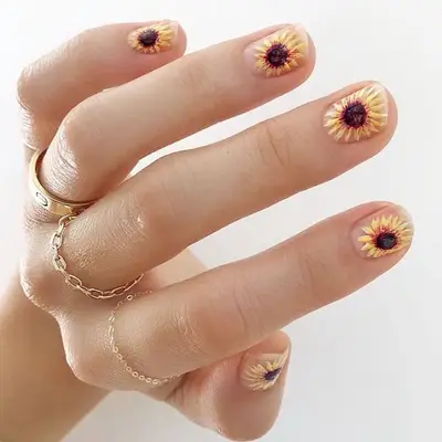 Short nude nails with a large detailed sunflower design on each nail
