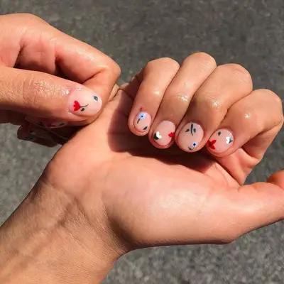 Short nude nails with tiny bloom nail art flecked throughout