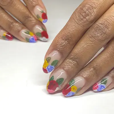 Nude almond-shaped nails with multi-colored floral tips