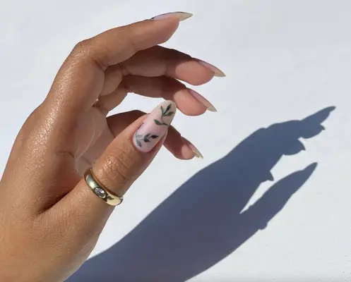 Nude matte almond-shaped nails with green ivy vines