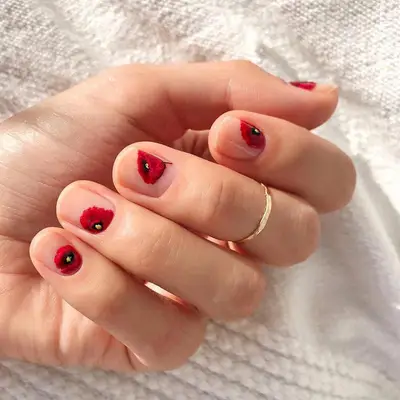 Short nude nails with poppies at the corner of each nail