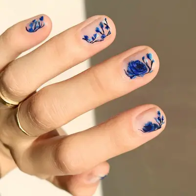 Short nude nails with blue floral nail art