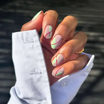 pistachio green and nude nails with red swirls