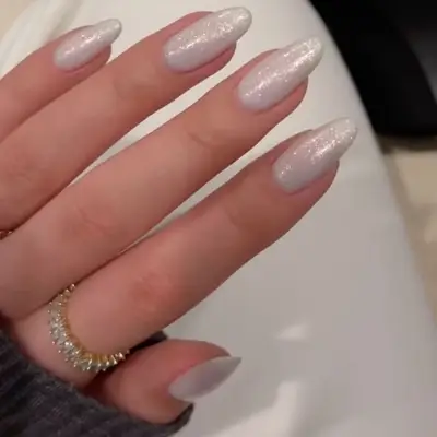 close up of milky white nails topped with silver sparkle sheen