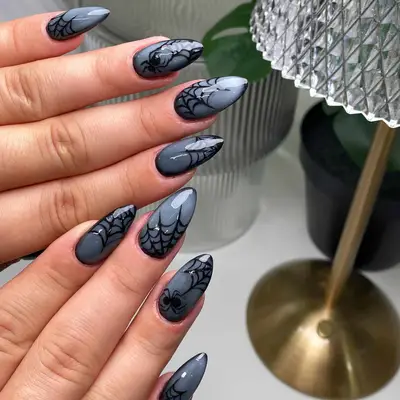 a stormy gray manicure topped with spiderwebs and spiders