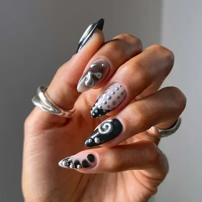 an mismatched manicure in shades of black and silver chrome