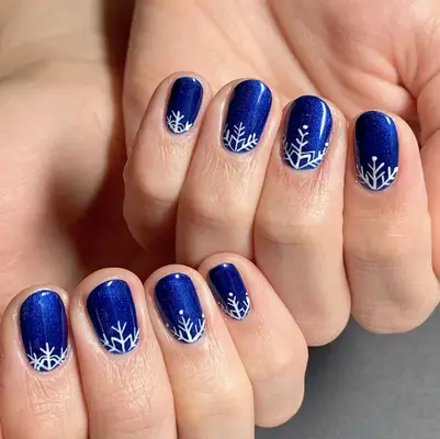 deep blue nails with white snowflakes at base