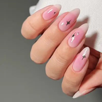 Sheer pink manicure with gold star and moon charms