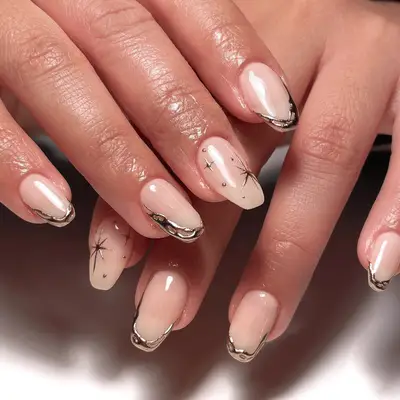 Pale pink manicure with chrome star nail designs