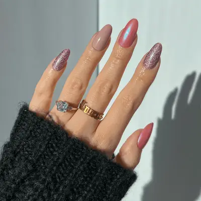 Close up of pink nails with alternating, chrome, glitter, and matte finishes.