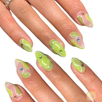 Green and white wavy pattern nails with diamond accents