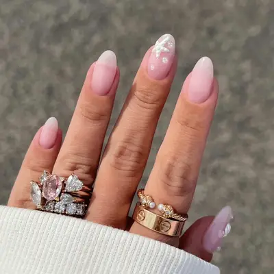 Close up of nude oval nails with white seashell and star fish accent nails.