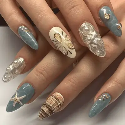 Close up of a mismatched ocean and sand manicure, with seashell details.