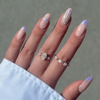 Cose up of purple chrome French nails with seashell and starfish art.