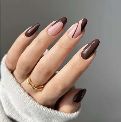 Close up of a chocolate brown manicure with french tip and solid nails