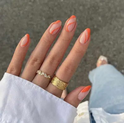 Close up of a swirly orange manicure