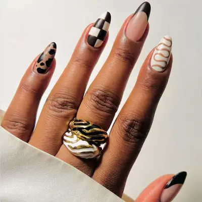 Close up of a short mix and match manicure in shades of brown and neutrals