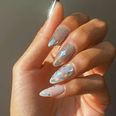 a mismatched manicure with sparkly polish and holographic accents