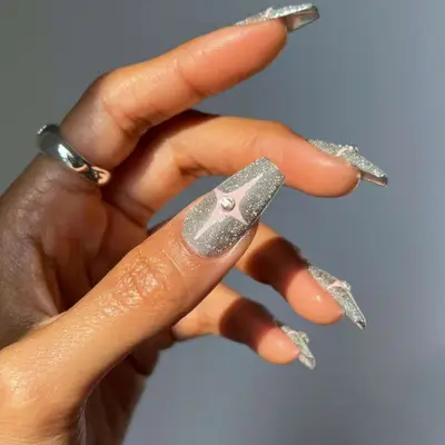 a silver velvet manicure topped with star designs