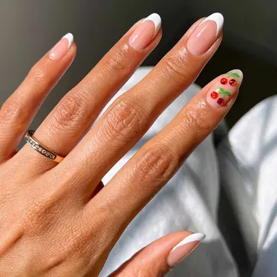 French manicure with cherry gemstone details