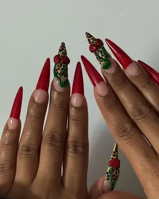 Close-up of hands with long red and intricately designed nails