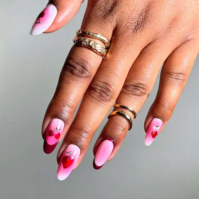 Hand with decorated nails, hearts in varying shades