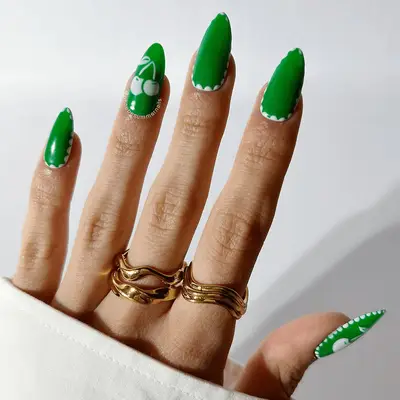 green almond nails with white borders and cherry accent design
