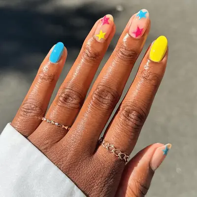 vibrant blue and yellow nails with star accent nails
