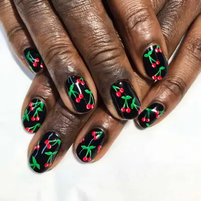 black nail polish with red and green cherry design 