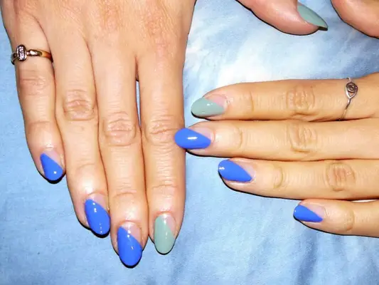 A set of mismatched nails, featuring negative space designs with different shades of blue