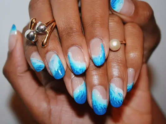 Negative space manicure with ocean waves.