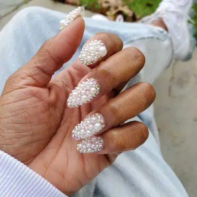 Manicure covered in various sizes of pearls and iridescent studs
