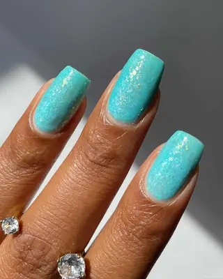a square glittery aquamarine manicure
