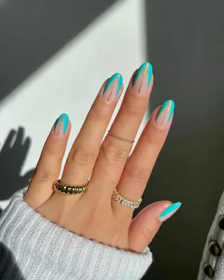 a turquoise abstract manicure with gold stripes down the center