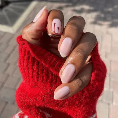 Subtle red blood drip nails on milky pink base